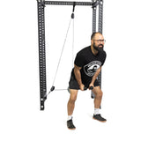 A person with glasses and a beard uses the Bells of Steel Tricep Rope Extension on a cable machine. They're focused on precise tricep targeting, wearing a black shirt, shorts, socks, and sneakers against a plain white background.