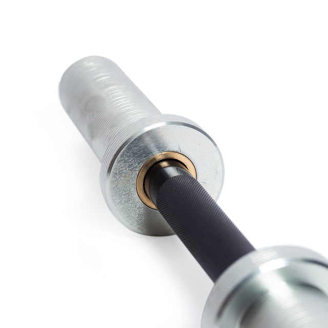 Close-up of a metal Loadable Dumbbell Handle, focusing on the sleeve and knurled grip. This gym equipment from Bells of Steel is placed on a white background, highlighting its shiny metallic texture and intricate design details similar to Olympic bars.