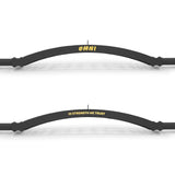 Two black curved bars feature text: "OMNI" in yellow on top, referencing the Bells of Steel Omni Bar, and "IN STRENGTH WE TRUST" in yellow on the bottom. The bars are horizontally aligned against a white background.