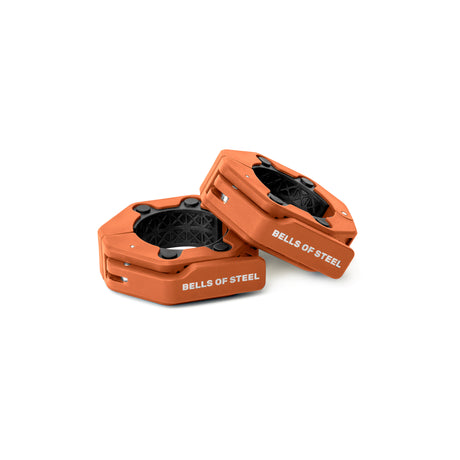 Two orange, hexagonal Magnetic Clamp Collars from Bells of Steel with black centers and branding are shown on a white background, designed to provide cushioning and support during weightlifting.