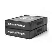 The black rectangular Deadlift Pads (Pair) by Bells of Steel are stacked, with "BELLS OF STEEL" on the side and handles for easy carrying, making them ideal silencer pads.