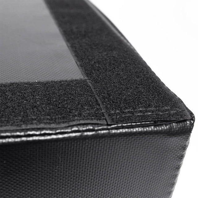 A close-up shows a black, textured surface with a smooth section bordered by a rougher edge. The design has sharp corners and clean lines, possibly part of the Deadlift Pads (Pair) by Bells of Steel.