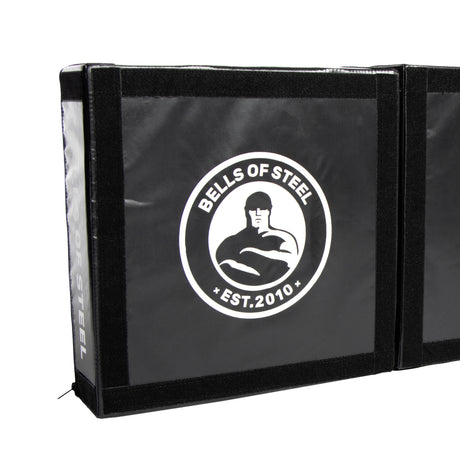 Black Deadlift Platform Drop Pad Pair by Bells of Steel, features a white "BELLS OF STEEL EST. 2010" logo with a muscular figure. Reinforced edges add durability; ideal for absorbing impact and protecting floors during workouts.