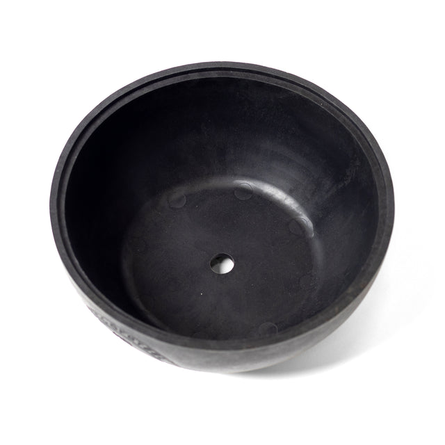 A black, circular Plastic Bottom for Adjustable Kettlebell by Bells of Steel, featuring a central hole and resembling a kettlebell base, is depicted against a white background.