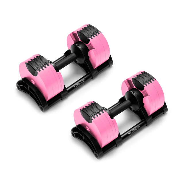 Nuobell's NÜOBELL Adjustable Dumbbells with pink and black machined steel plates sit on a white surface, highlighting their compact design and robust build, ideal for home workouts.