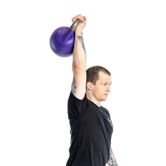 Against a crisp white background, a person in a black shirt skillfully lifts an Adjustable Competition Kettlebell by Bells of Steel overhead with one hand, showcasing tattoos on their arm.