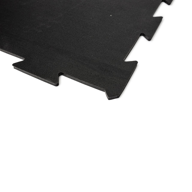 A close-up of the Bells of Steel Black Puzzle Mat, showcasing interlocking edges that allow seamless connection with other mats.