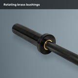 A close-up of the Bells of Steel Short Rackable Barbell with rotating brass bushings, set on a gray surface. The text “Rotating brass bushings” appears at the top, emphasizing the durable design of this 69-inch barbell—an ideal choice for any compact home gym.