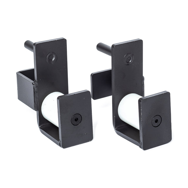 A pair of black metal Roller J-Cups from Bells of Steel, featuring durable nylon rollers, a rectangular shape, and cylindrical components with mounting holes, are displayed side by side on a white background.