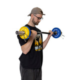 A man in glasses, a backward cap, and a black tee does a bicep curl with an Olympic barbell secured by Bells of Steel Spring Collars and blue/yellow plates against a white background.