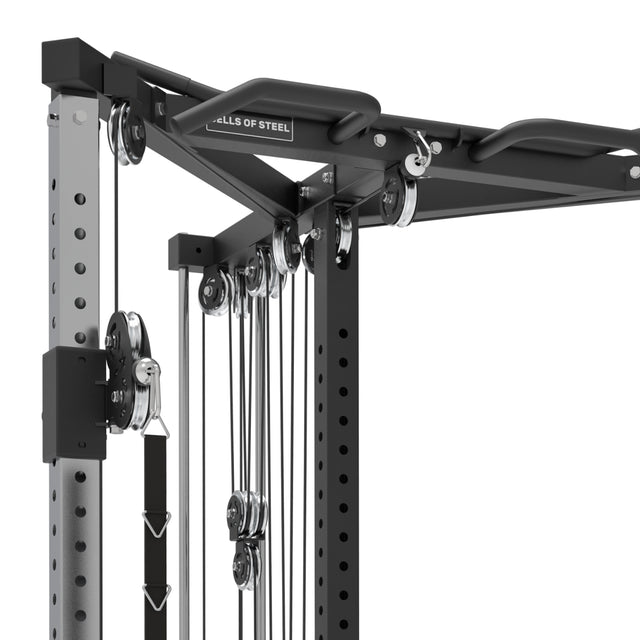 Close-up of a Bells of Steel home gym system with pulleys and cables. The All-in-One Trainer's black frame and metal components support strength training, integrating seamlessly for comprehensive workouts.