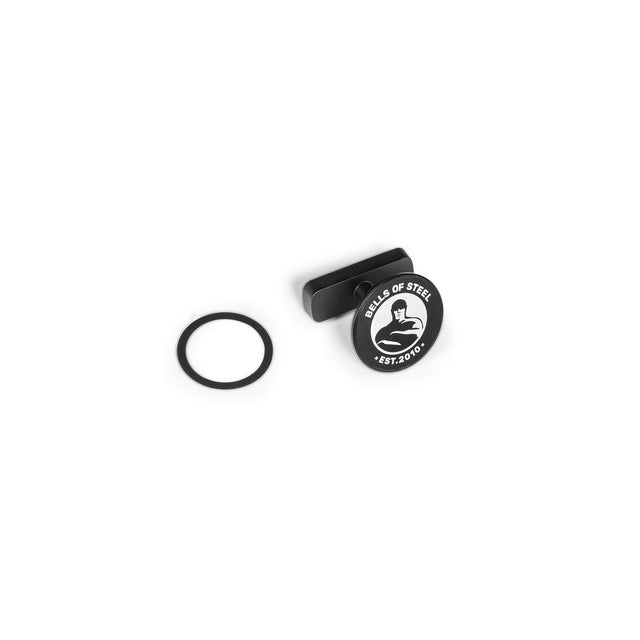 The Bells of Steel Selfie Sentinel - Magnetic Rack Phone Holder features a black circular magnet with “BELLS OF STEEL EST. 2010” and a flexing arm logo, a black rectangular attachment, and a separate black rubber ring. Shown on a white background, it’s perfect as a MagSafe-compatible magnetic phone mount or gym phone holder.