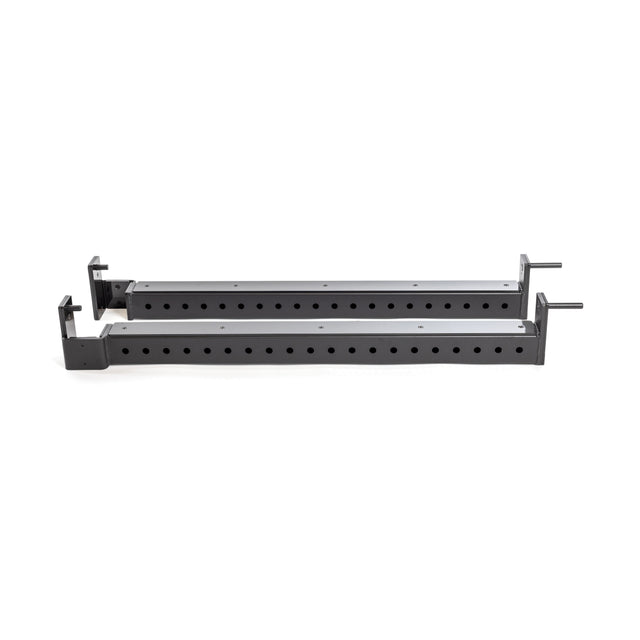 The Flip-Down Safeties by Bells of Steel are a pair of black, perforated metal bars with mountable brackets on each end, designed for use in a power rack. These bars feature evenly spaced holes along their length, allowing for easy adjustment, and stand out against a plain white background.