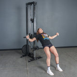 A person uses the Bells of Steel Aluminum Handles Pair with Bearings to perform a cable chest fly exercise in a gym, leaning back with arms extended and gripping the adjustable handles. They wear a black t-shirt, shorts, and sneakers.