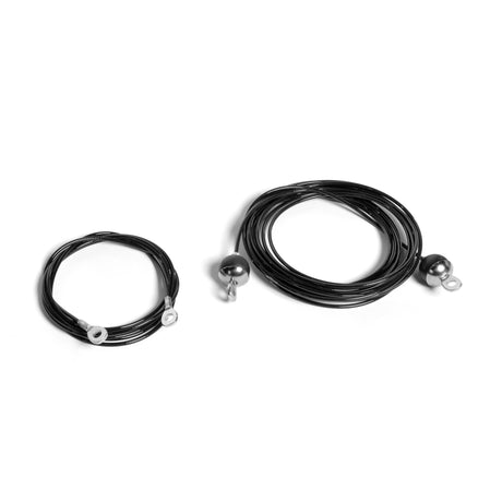 Two black coiled cables from Bells of Steel for a Plate-Loaded Cable Tower rest on a white background. One is thinner, the other thicker, suggesting different gauges. Their sleek nylon finish adds elegance to their robust design.