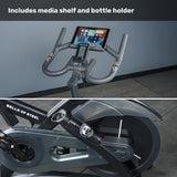 Two close-up views of the Bells of Steel Blitz Indoor Cycling Bike: one features adjustable handlebars with a media shelf and bottle holder, while the other highlights the flywheel and "BELLS OF STEEL" branding on the frame.