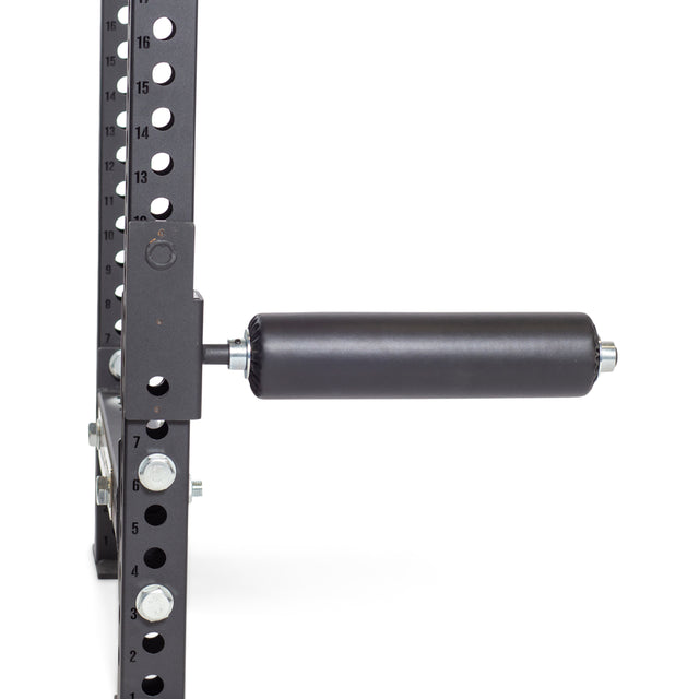 A close-up of the Bells of Steel Split Squat Leg Roller Rack Attachment, featuring a padded cylindrical bar for Bulgarian split squats. It's attached horizontally to a durable, perforated metal frame with numbered holes for adjustable positioning.