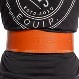 A person in a black shirt with a circular logo wears a wide brown 10mm Leather Weightlifting Belt by Bells of Steel, featuring an embossed "BELLS OF STEEL" text. It is securely fastened around the waist with its single-prong buckle.