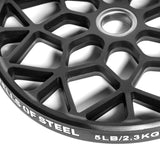 Close-up of a black geometric-patterned weight plate featuring "Bells of Steel" and "5LB/2.3KG" on the edge. This Technique Plate has a central circular hole, ideal for barbell use in your home gym.