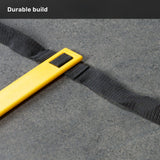 Close-up of a yellow plastic piece attached to a black strap on a gray surface, with the words “Durable build” in white text at the top left corner. Part of the Bells of Steel Agility Ladder and Leg Cord Bundle, this component is designed for use with leg resistance bands and resisted speed training.
