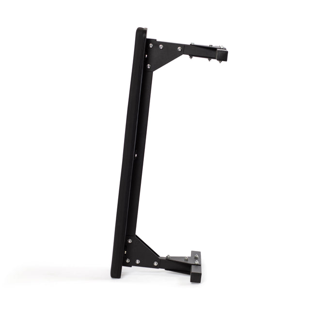 Side view of a black, wall-mounted rig with adjustable arms and visible screw holes, designed to support equipment or monitors. Its sleek, sturdy design is minimalist and functional, mirroring the reliability of the Flat Utility Bench by Bells of Steel.