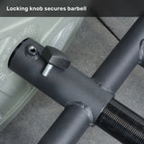 Close-up view of a black locking knob securing a Viking Press Attachment by Bells of Steel to an Olympic bar, with the text "Locking knob secures barbell" at the top.