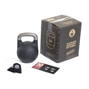 The Mark Wildman Adjustable Kettlebell by Bells of Steel, featuring a sleek black finish with an engraved logo, lies next to its cardboard box. Included are a cloth and two information cards. The packaging states: "12 to 20.5 KG Adjustable Kettlebell" by Wildman Athletica.