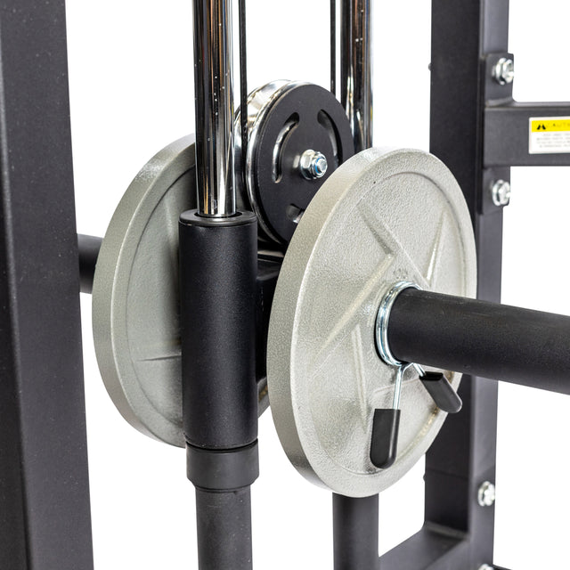 Close-up of Bells of Steel Functional Trainer, showcasing weight plates on a bar with clips. The setup features weight stacks and a pulley system with shiny metal parts and a sturdy black frame, ideal for diverse cable machine exercises.