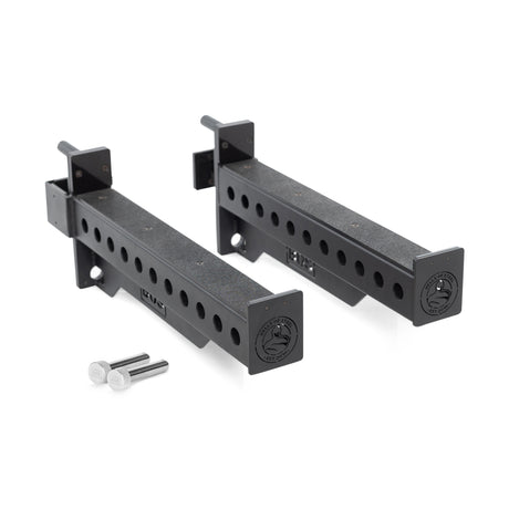 The image shows the Bells of Steel Spotter Arms Rack Attachment. These are heavy-duty black metal arms with UHMW lining, multiple adjustment holes, and feature two securing metal pins nearby for attaching to a weightlifting rack.