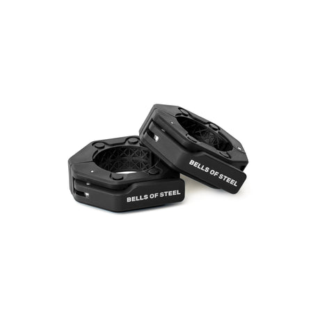 Two black, hexagonal Magnetic Clamp Collars by Bells of Steel with white logo text are displayed on a white background—one standing upright, the other leaning—showing how they securely hold weight plates in place.