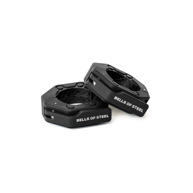 Two black, hexagonal Magnetic Clamp Collars by Bells of Steel with white logo text are displayed on a white background—one standing upright, the other leaning—showing how they securely hold weight plates in place.