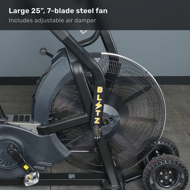 Close-up of the Bells of Steel Blitz Max Air Bike, a premium fitness machine with a 25-inch, 7-blade steel fan and adjustable air damper. The black bike with yellow accents is placed on a gray floor against a gray wall.