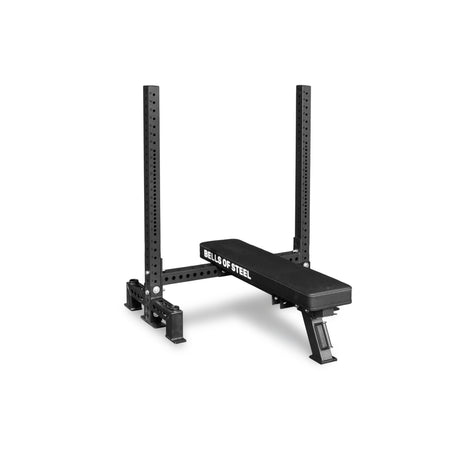 The Bells of Steel Two Post Converter Bench, black with an attached squat rack and spotter arms, is shown on a white background—a versatile bench station with a two-post setup.