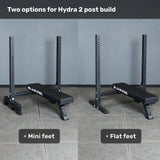 Two Bells of Steel Hydra Two Post Converter Benches sit side by side; the left has mini feet, the right has flat feet. Text labels show foot options for configuring a dedicated Hydra Two Post Converter Bench station.