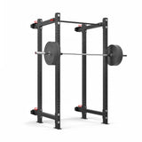 The Roc Foldable 4 Post Cage Builder by Bells of Steel is a black squat rack with modular components, adjustable safety bars, and supports up to 1,000 pounds. It features a sturdy structure with ⅝" holes on its 3" x 3" frame for easy equipment adjustment.