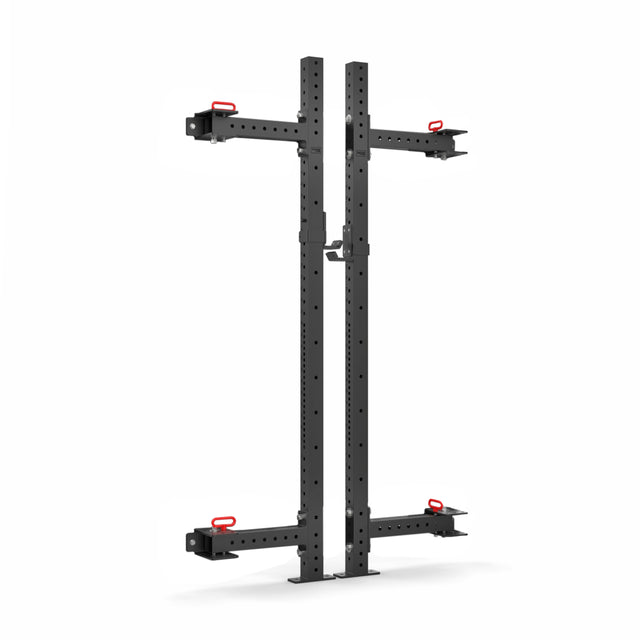 The Roc Foldable 2 Post Cage Builder by Bells of Steel is a black metal wall-mounted squat rack with adjustable arms and red hooks. It features modular components and multiple holes (3" x 3", ⅝") for easy customization, perfect for any home gym setup against a white background.