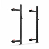 Displayed against a plain white background, the Roc Foldable 2 Post Cage Builder by Bells of Steel features tall, black metal stands ideal for a home gym, with modular components, multiple ⅝" adjustment holes, and red hooks for support.