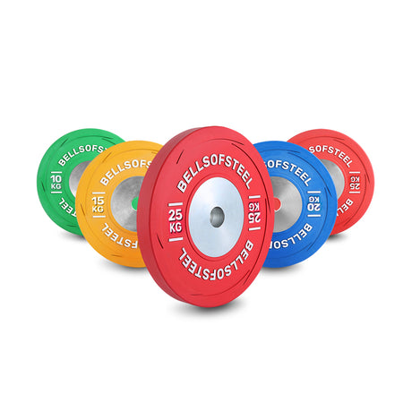 Five Bells of Steel KG Competition Bumper Plates—green (10kg), yellow (15kg), blue (20kg), and two red (25kg)—stand upright, showing IWF specs, bold branding, and clear weight labels for Olympic weightlifting.