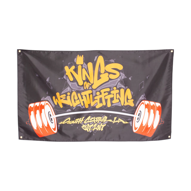 The "Bells of Steel" flag showcases the phrase "Kings of Weightlifting" in a striking graffiti-style font, flanked by vibrant red and white barbells. Beneath, the text "South Central, LA, Est. 2017" stands out against a sleek black backdrop. This piece is ideal for enhancing your gym decor or making a standout addition to your home gym flag collection.