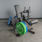 The Bells of Steel Legacy Leg Extension / Hamstring Curl Machine - Plate Loaded is set on a gray floor against a plain gray wall in a home gym, featuring adjustable settings for leg exercises.