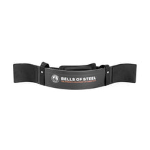 The Bells of Steel Arm Blaster is black with padded straps and “BELLS OF STEEL, THE STRENGTH EQUIPMENT OF CHAMPIONS” on the front, designed to provide superior support during bicep curls and weightlifting.