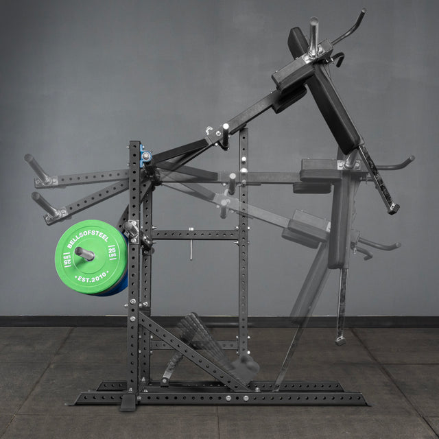 The Bells of Steel Pandemonium Squat – 3-in-1 Pendulum Squat / Calf Press / Viking Press Machine is pictured in a home gym with a weight plate, showing its range of motion using adjustable pads and handles.