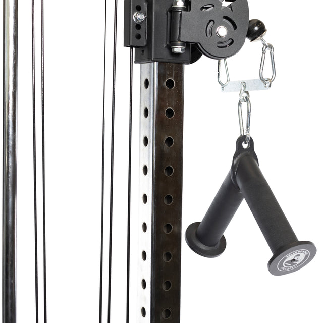 Close-up of the Bells of Steel "Fat Bar - Tricep Pressdown" gym machine, highlighting its metal construction with pulleys, cables, and two black rubber handles connected by hooks. Designed to enhance grip strength, it features an industrial, robust design with a perforated frame that allows for adjustable settings ideal for tricep pushdowns.