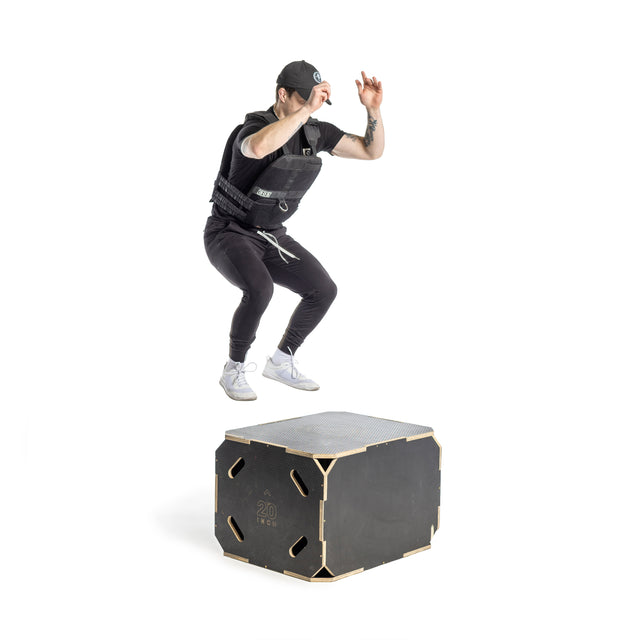 A person in athletic clothing and a cap jumps onto a sturdy wooden plyo box marked "20" using Bells of Steel Canada's Weighted Vest and Plates, increasing workout intensity with added resistance.