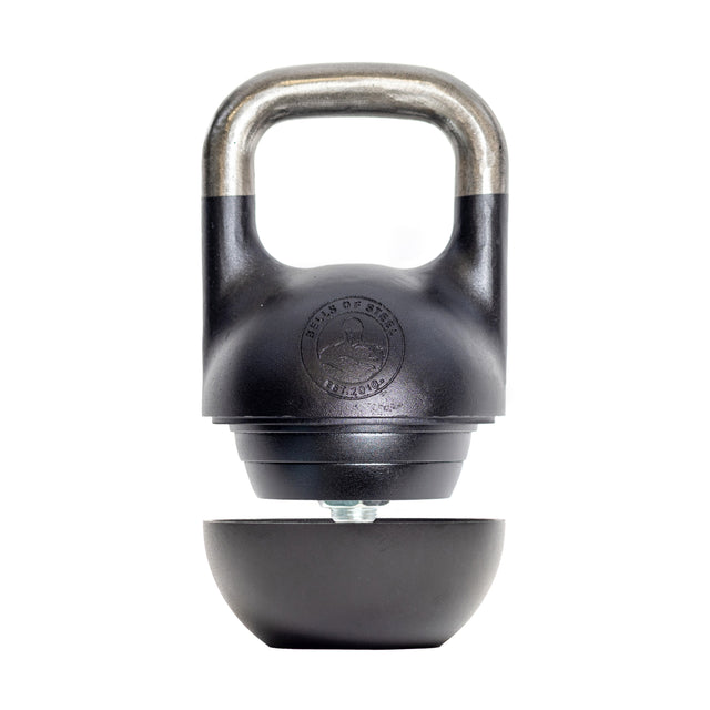 A Mark Wildman Adjustable Kettlebell from Bells of Steel, featuring a detachable base and silver handle, is ideal for weight training. It has a black finish with a circular emblem and reveals an adjustment mechanism when the base is removed.